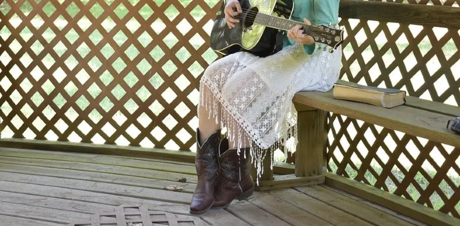 Girl wearing cowboy boots and a dress at a wedding