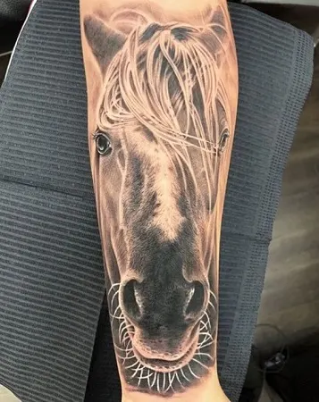 Unique horse head tattoo on a womans arm