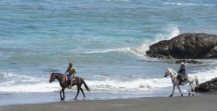 Two horse riders on the Ten Mile Beach in California