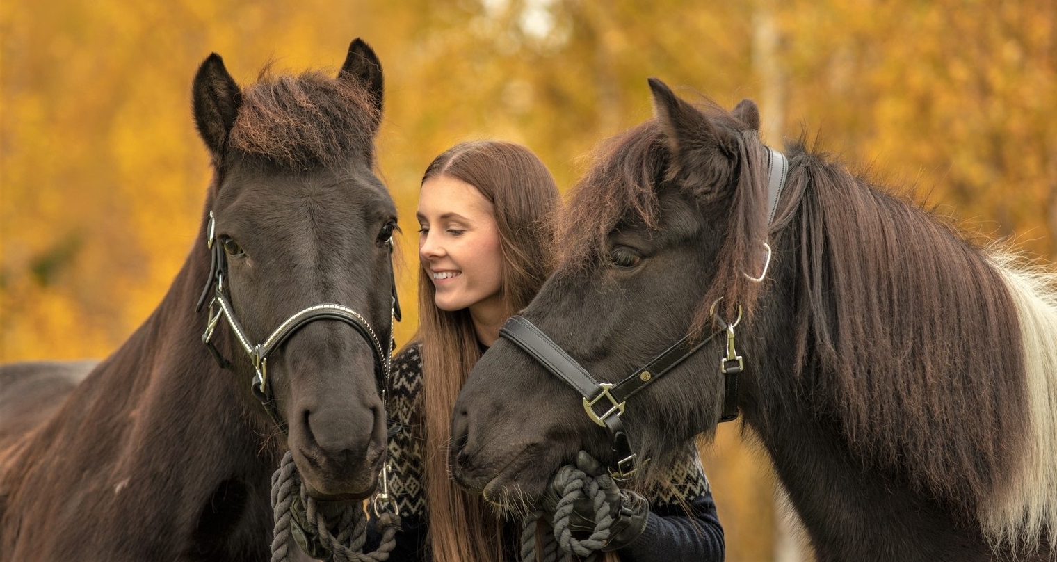 Is horse riding cruel? A girl holding two horses