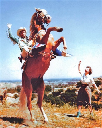 Roy Rogers on his golden palomino Trigger, with wife and costar Dale Evans