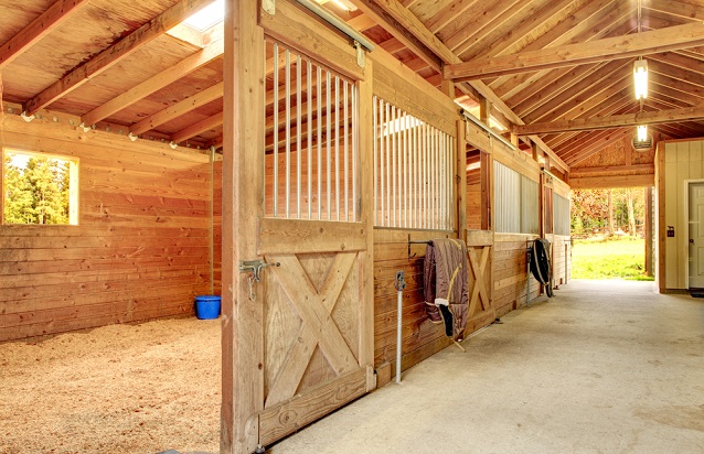 Inside of a barn with wooden stables