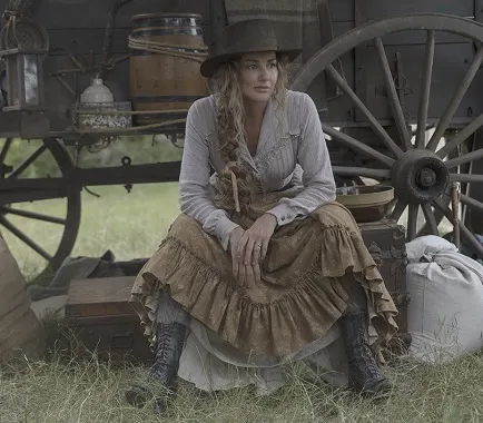 Margaret sitting beside a wagon in the 1883 TV show