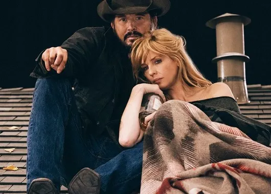 Rip Wheeler and Beth Dutton on a house roof drinking whiskey and looking at the stars