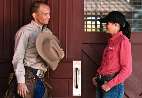 Jimmy and Emily smiling at each other at the 6666 Ranch in Yellowstone TV series