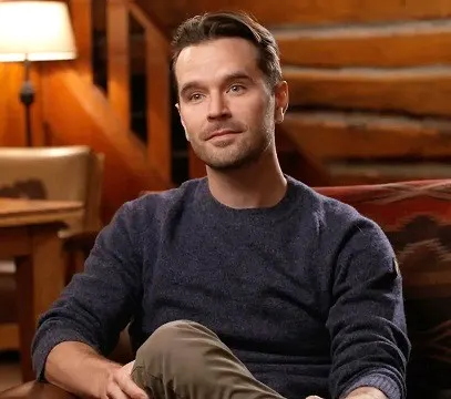 Graham Wardle sitting down on a sofa for a podcast interview about Heartland