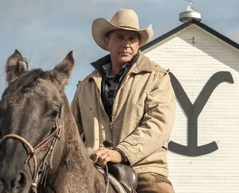 John Dutton kører på en hest med Yellowstone Dutton Ranch Main Barn i baggrunden