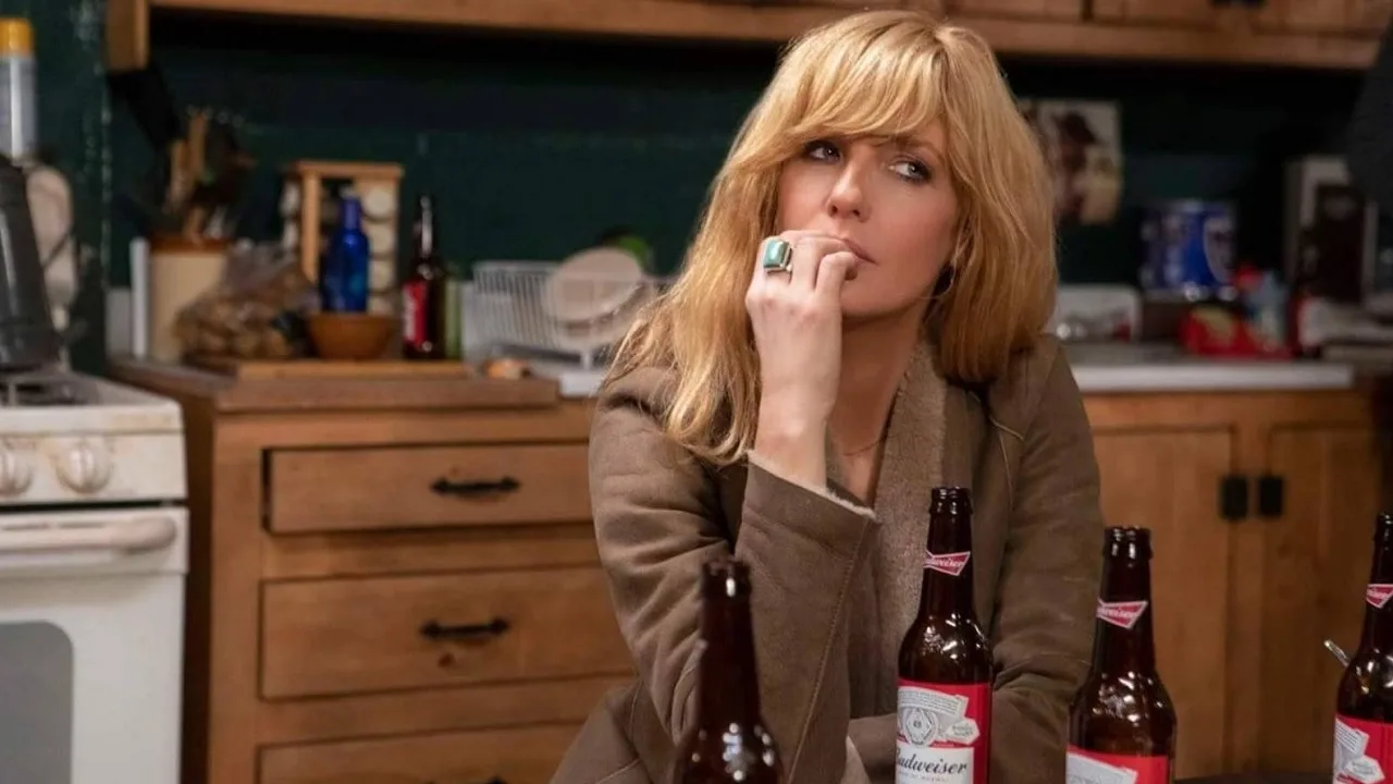 Beth Dutton leaning on a table of bottles of beer in Yellowstone