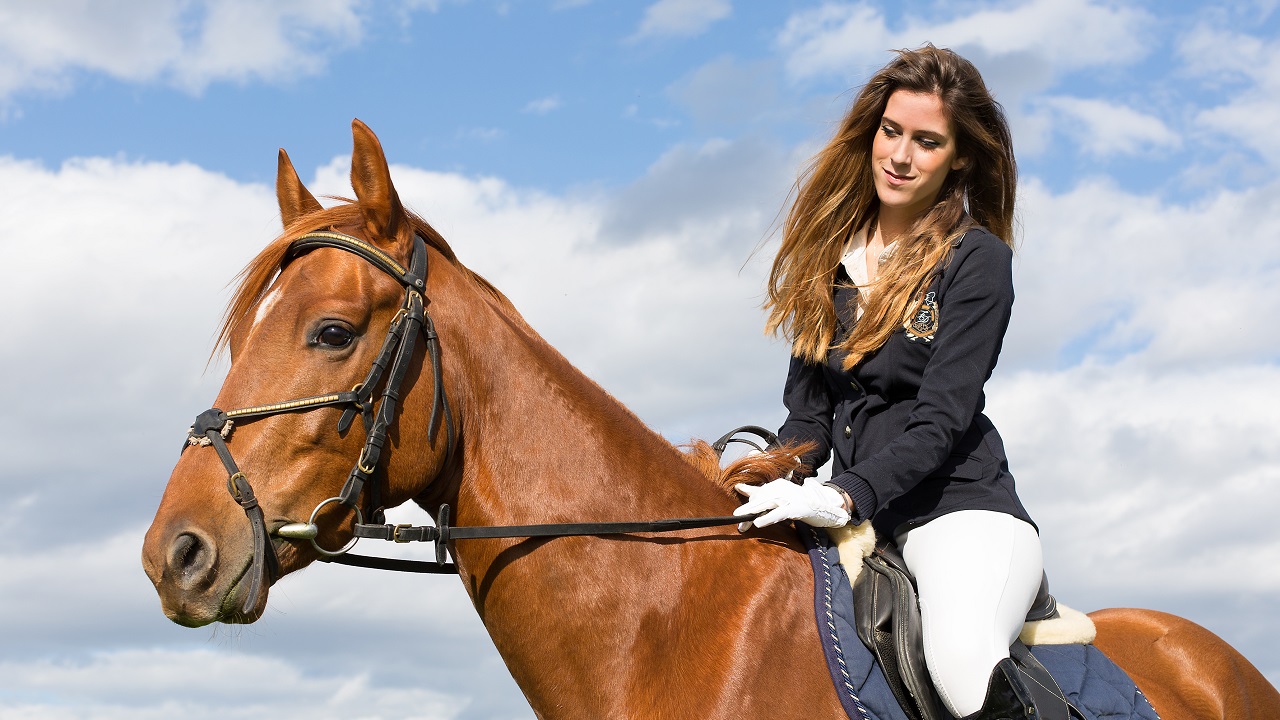 Woman riding a horse and wearing a smart uniform