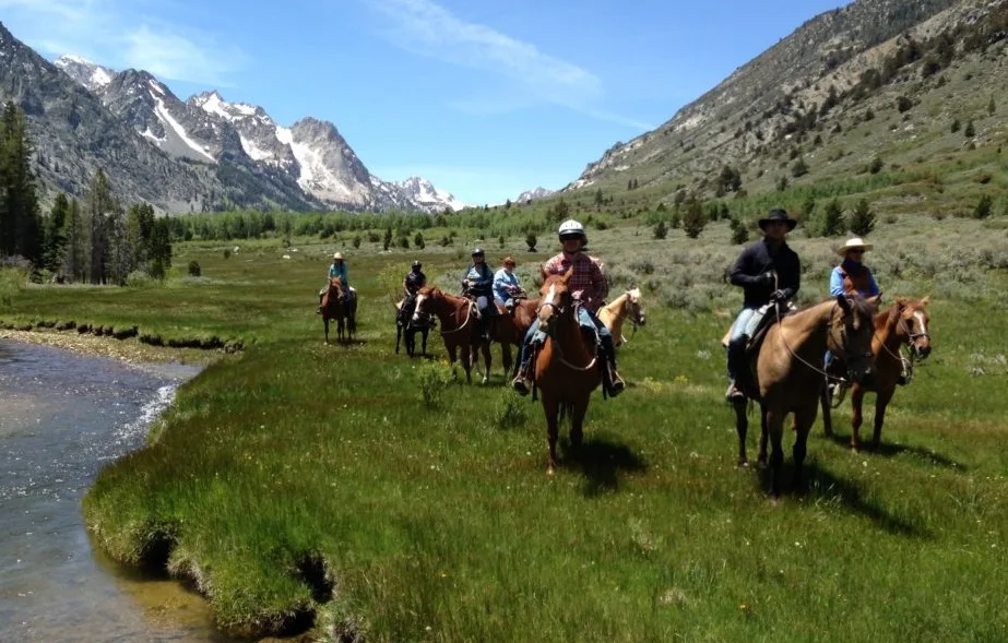 Horse trail ride beside river and in a mountain valley at Hunewill Guest Ranch in California