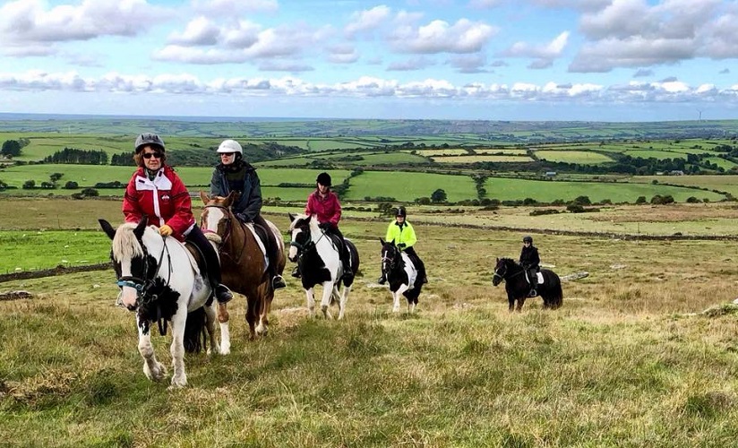 Bodmin Poldark Trail with guest riders and horses going through a field