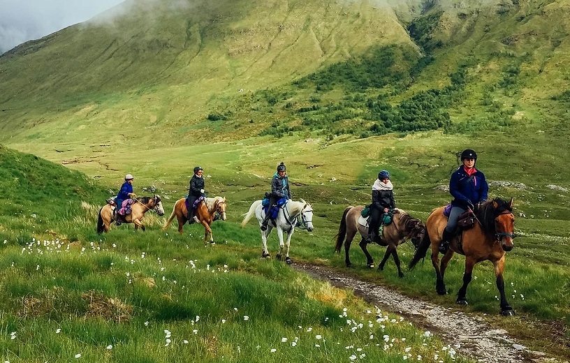 Wild West Highlands Ride tour group riding horses through the Scottish countryside