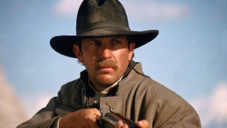 Close up of Kevin Costner in cowboy gear holding a shotgun in a western movie